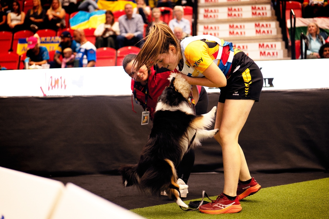 Andrea Prezzi met haar hond na een agility run — moment van verbinding op de wedstrijd